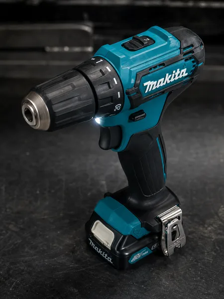 Шуруповёрт Makita на тёмной поверхности с включённой подсветкой